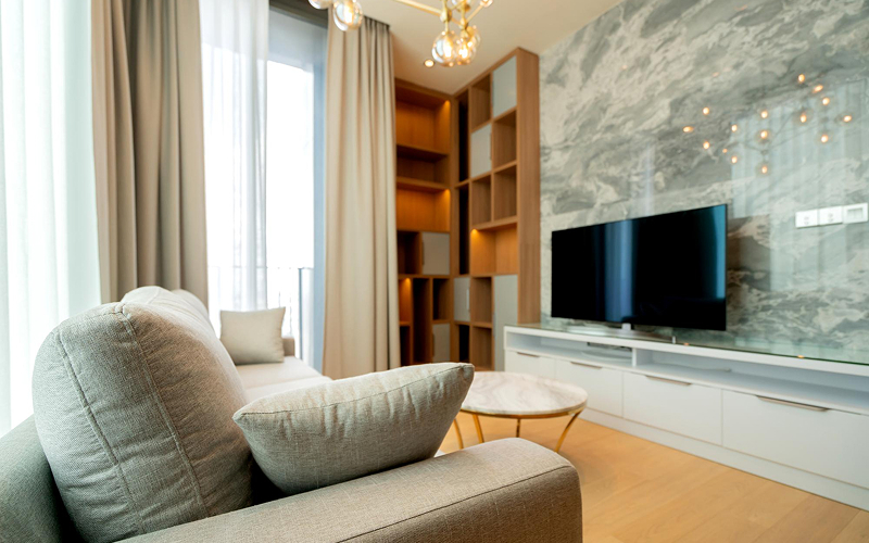 A bright, modern, small Singapore living room featuring compact furniture, hidden storage, a TV console, and a sleek coffee table